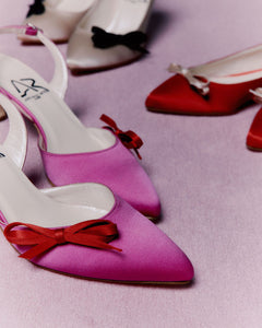 Décolleté slingback in raso fucsia con fiocco a contrasto rosso, interno foderato in pelle, suola in cuoio, tacco 55 mm