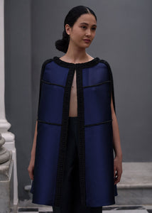 Antonio Riva Milano cappa da cerimonia Brigid in mikado blu dal taglio ampio con dettagli geometrici neri e spacchi verticali sui lati, Made in Italy